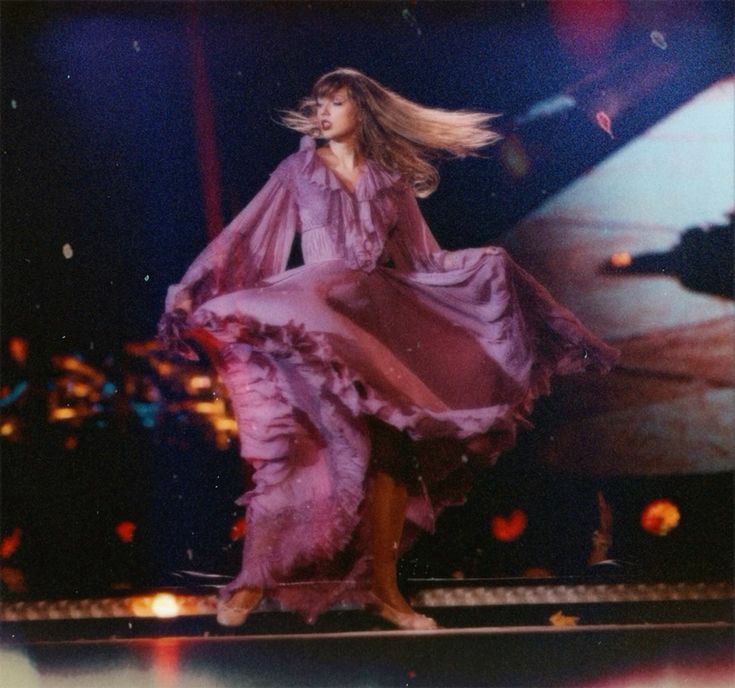 Taylor swift twirling in the purple folklore dress  
