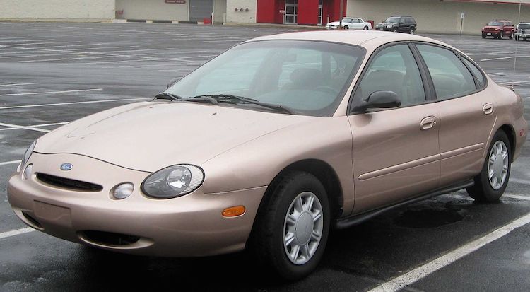 A cream colored third generation Ford Taurus