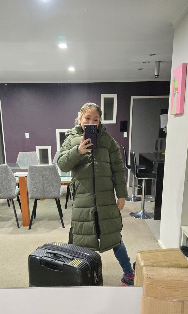 Me in a mirror, suit case in foreground. In a gigantic puffer jacket
