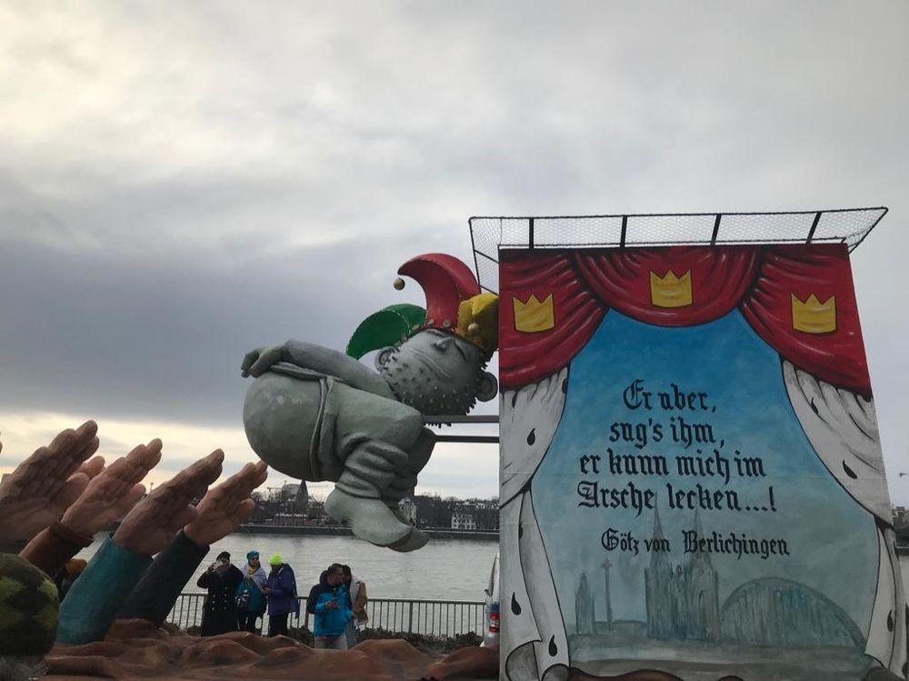 Karnevalwaagen:
Ein Narr steckt sich aus scheiße erheben Händen, welche den "Hintelgrüß" mit Afd binden zeigen seinen Hintern entgegen.