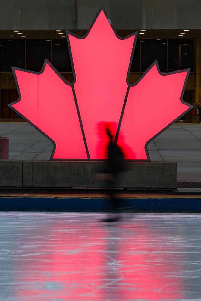 A glowing maple leaf lights up an ice rink in downtown. 