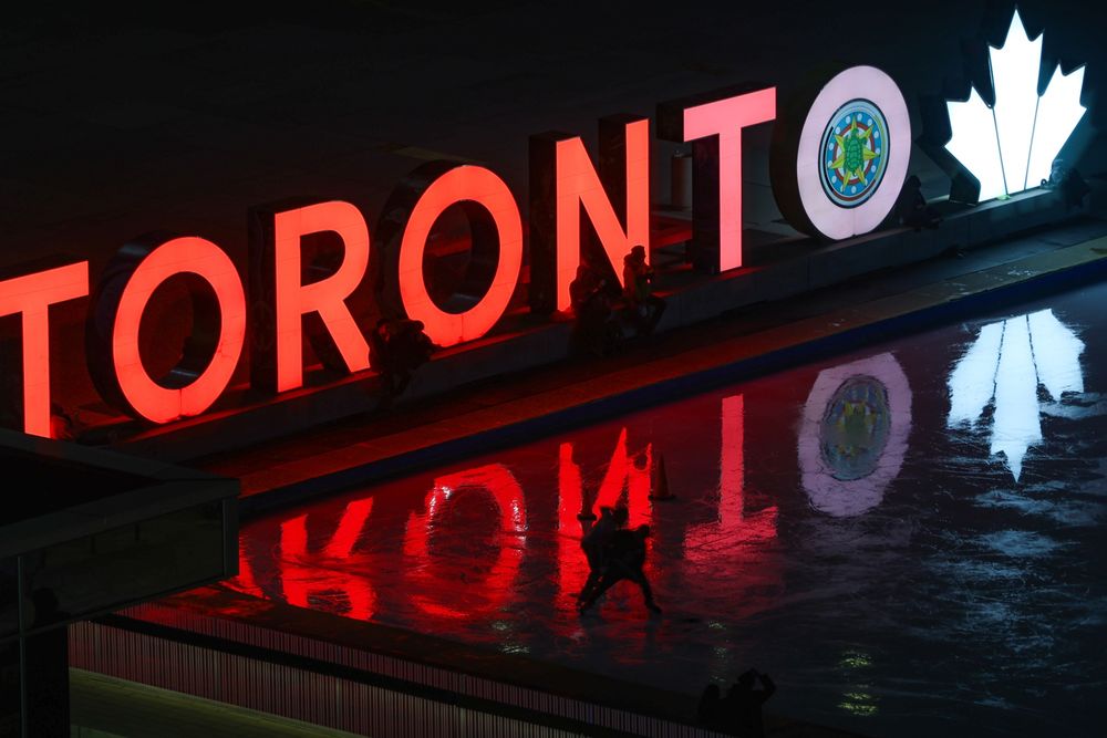 A glowing Toronto sign lights up an ice rink in downtown. 