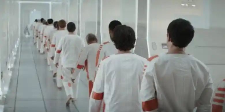 Cassian Andor and other prisoners walking down a hallway.