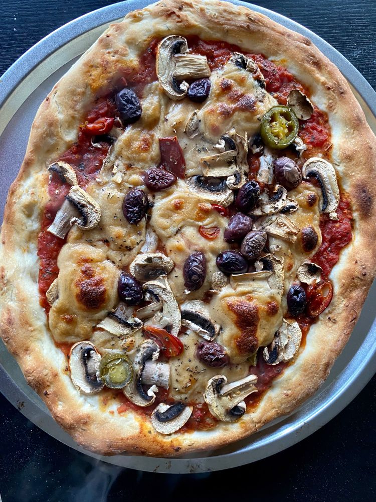 Pizza maison avec champignons, piment jalapeno, sauce tomate maison, olives kalamata, faumage maison