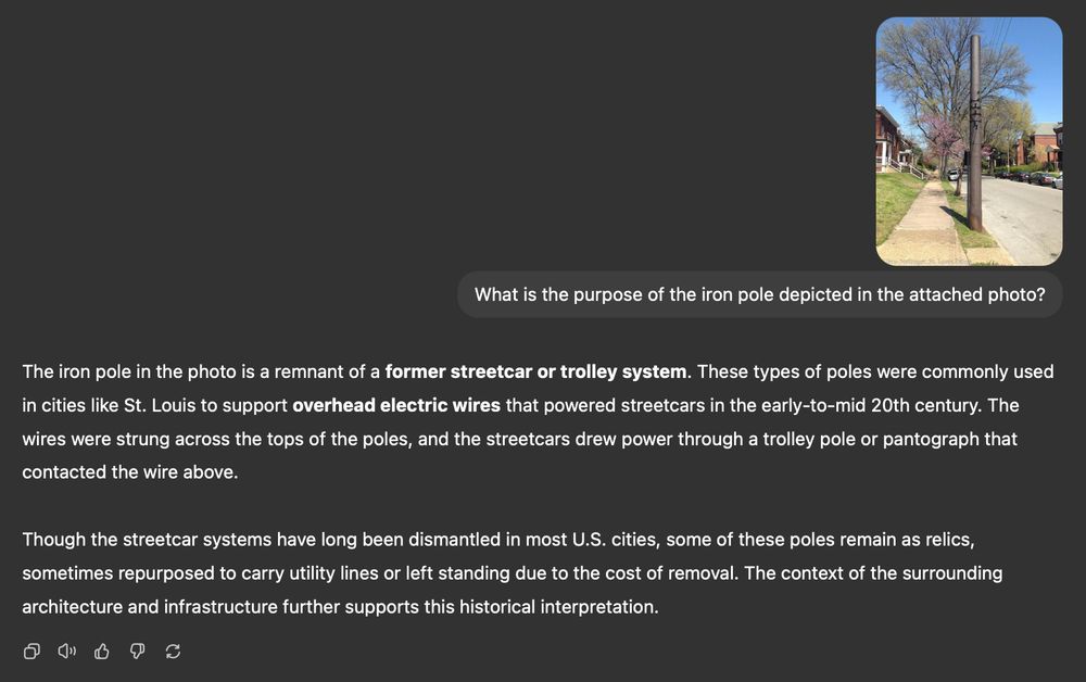 Screenshot of ChatGPT response to the question, "What is the purpose of the iron pole depicted in the attached photo?" with the response:

"The iron pole in the photo is a remnant of a former streetcar or trolley system. These types of poles were commonly used in cities like St. Louis to support overhead electric wires that powered streetcars in the early-to-mid 20th century. The wires were strung across the tops of the poles, and the streetcars drew power through a trolley pole or pantograph that contacted the wire above.

Though the streetcar systems have long been dismantled in most U.S. cities, some of these poles remain as relics, sometimes repurposed to carry utility lines or left standing due to the cost of removal. The context of the surrounding architecture and infrastructure further supports this historical interpretation."