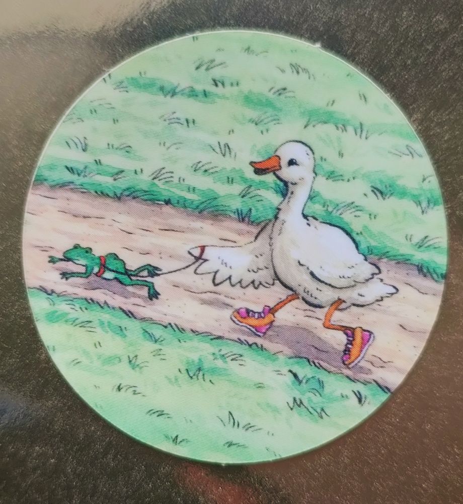 A sticker of a duck walking a frog like a dog