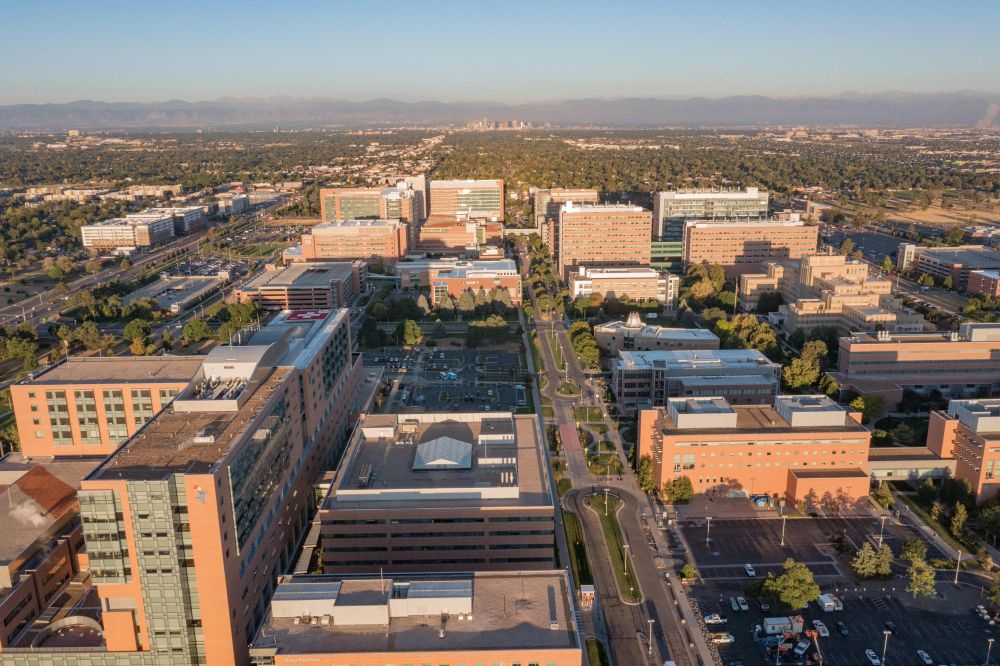 Aerial view of Anschutz Medical Campus's many buildings with the Rocky Mountains in the background.