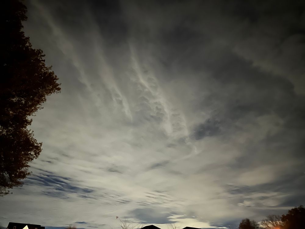 A sky covered with light colored clouds at night