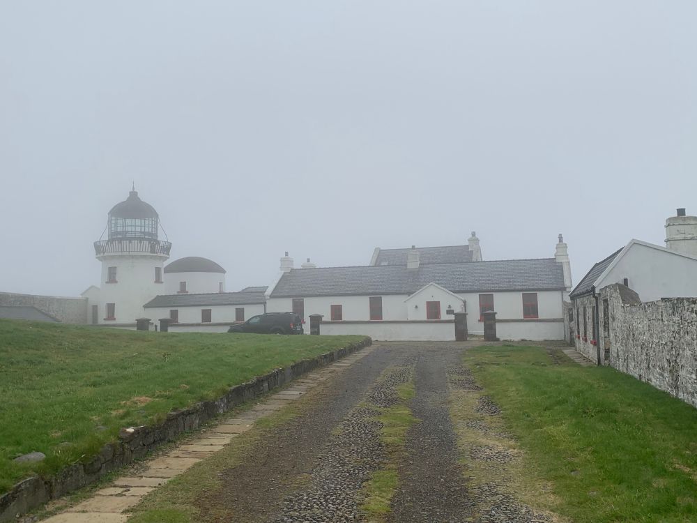 A lighthouse complex in the mist. 