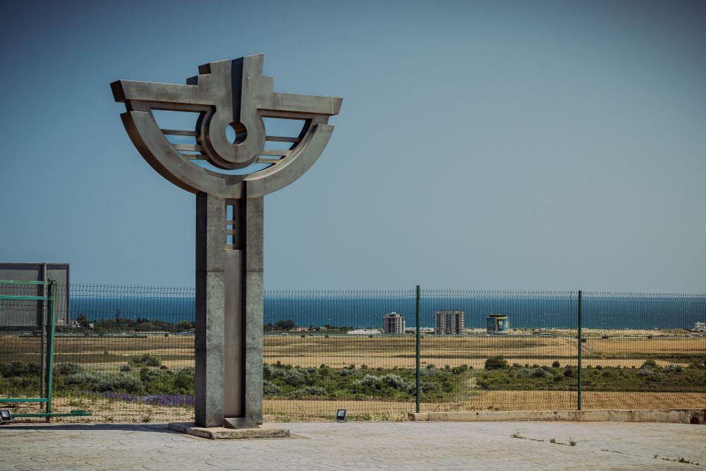 A large sculpture depicting a stylised eye against a blue sky. The Black Sea is visible on the Horizon.