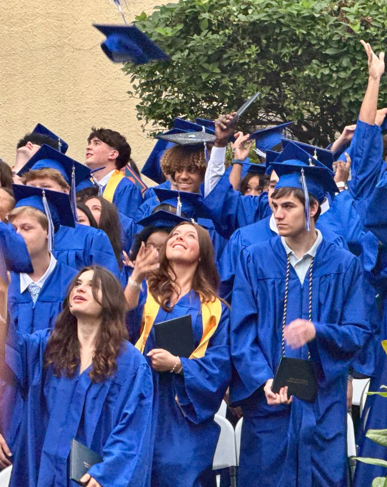 A high school graduate channeling Mary Tyler Moore as she throws her cap up in the air