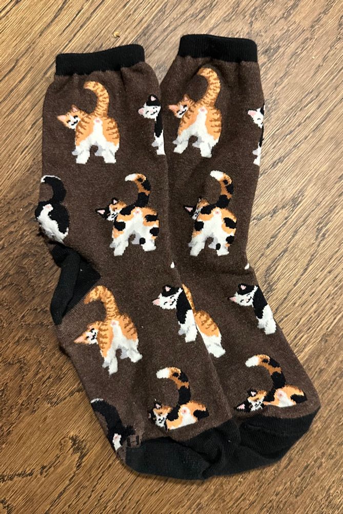 Brown socks with images of cats showing off their bums. 