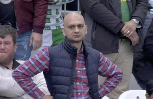 Disappointed football fan meme. A man dressed in a plaid shirt and a vest is looking at the camera. His hands are on his hips and he has a displeased look on his face.