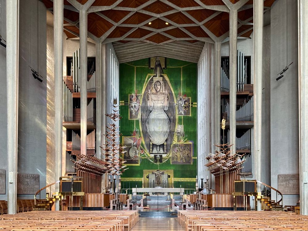 A view down a cathedral nave with a huge figure of Christ above the alter