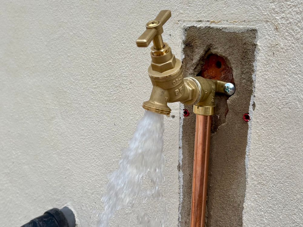 A bright shiny new tap is releasing water. There are no unwanted leakages or drips. 