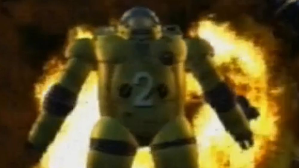 A heavily armoured yellow diving suit is being pushed towards the screen from an explosion in the distance.