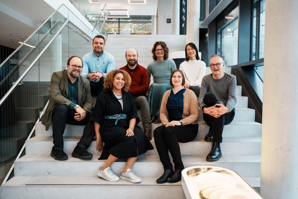Photo shows the EMBO Lab Leadership team sitting on a staircase on the campus in Heidelberg, Germany.