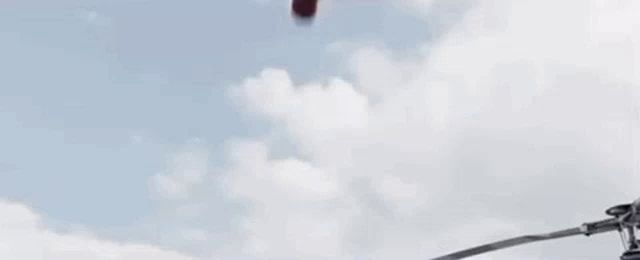 spider-man is holding captain america 's shield in his hand while jumping off a helicopter .