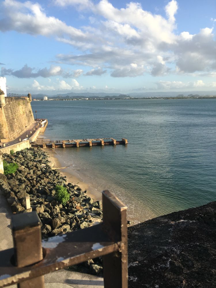 A cliffside view of water, a dock, and a beach