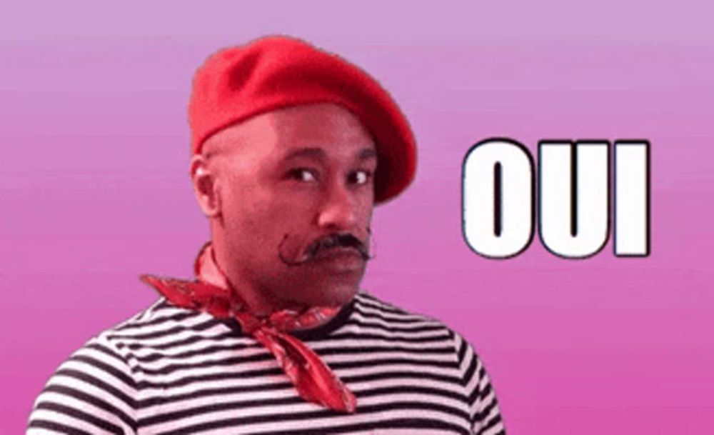 a man wearing a red beret and a striped shirt has the word oui written in white