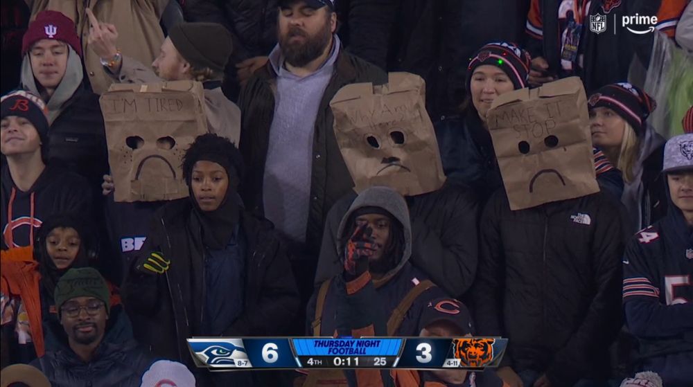 Three Bears fans wearing bags over their heads as their team completes a 6-3 loss to the Seahawks that was somehow even worse than that score infers.