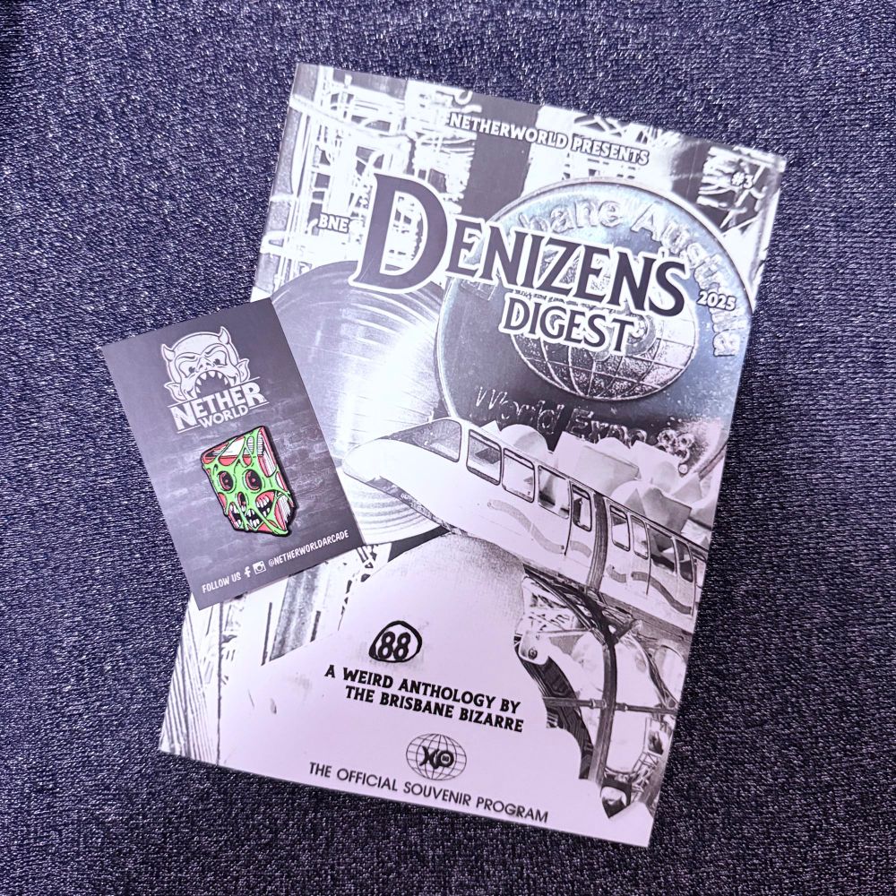 Photo of a copy of Denizen’s Digest, with a black and white Expo cover, and a creepy zine pin, on a glittery background. 