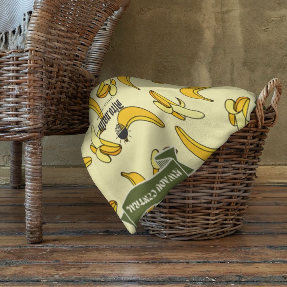 A soft, yellow Kwadu Central blanket lying atop a woven basket.
