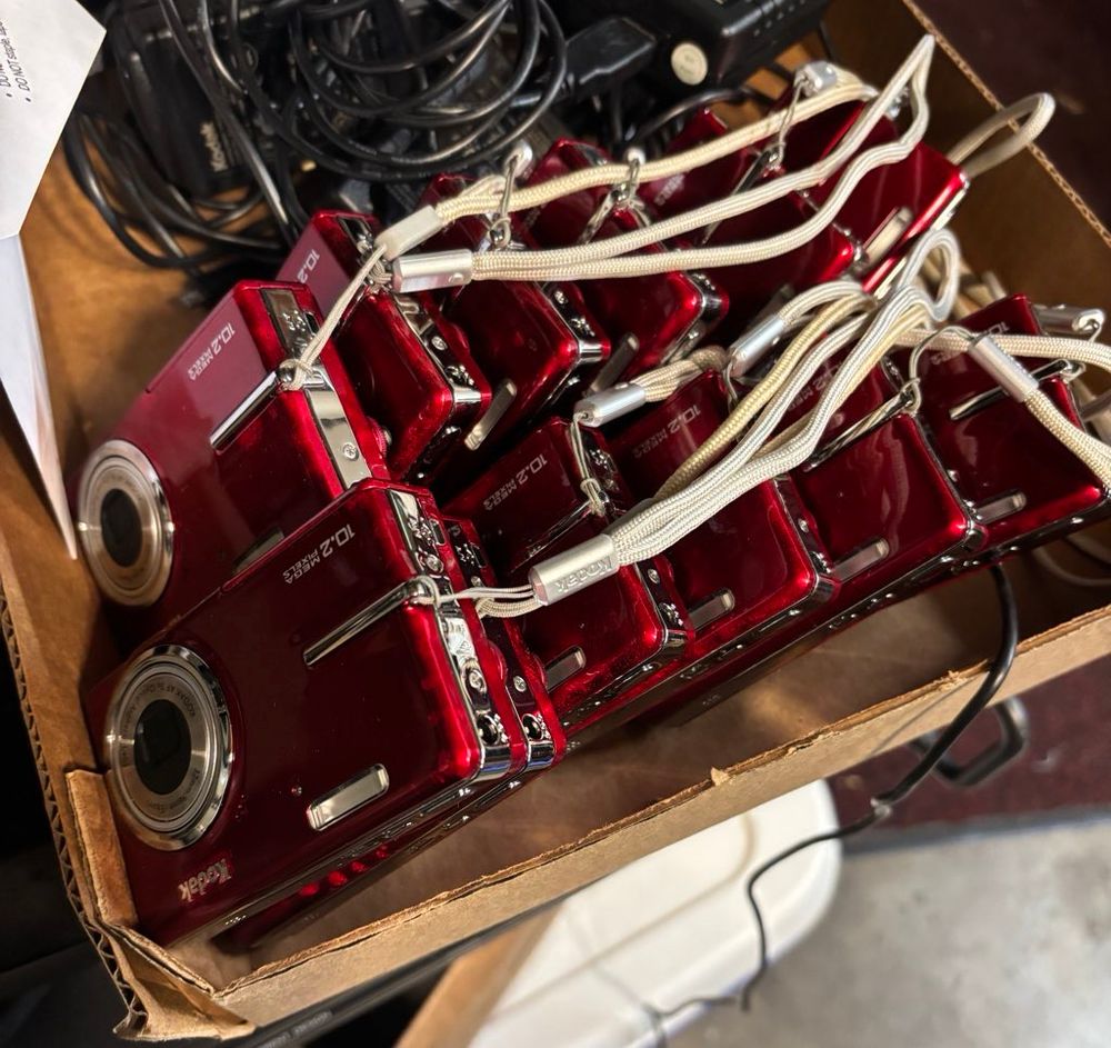 Photo of a dozen kodak coolpix cameras