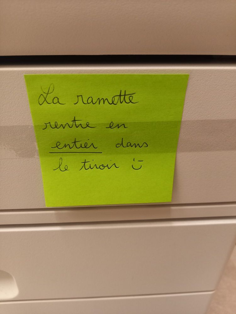 Un post-it collé sur le bac à feuilles de la photocopieuse : "la ramette rentre en entier dans le tiroir ;)"