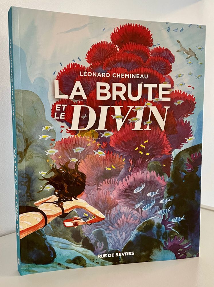 Couverture de La Brute et le Divin. Eva, l'héroïne, nage vers un corail géant.