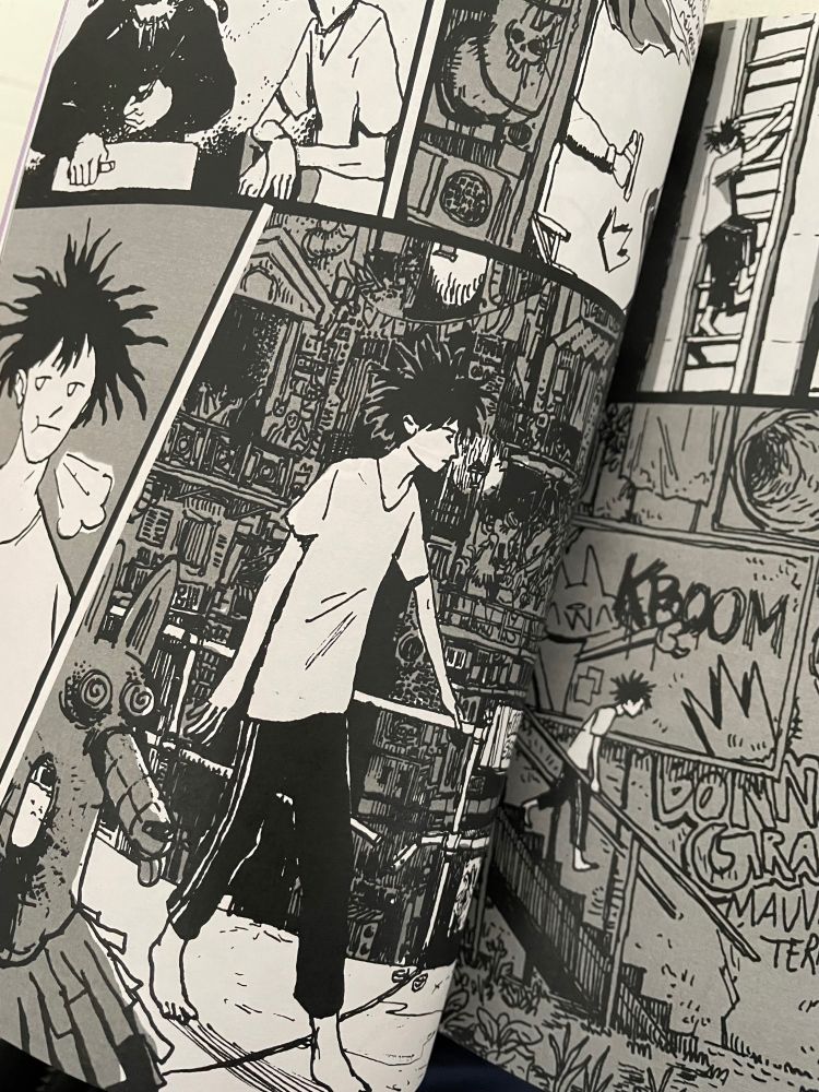 Planche en noir et blanc signée Kapé. 
Gaël, l'un des personnages principaux de l'univers imaginé par B*MO, marche seul dans la Métastation, un décor danse plein de graffitis.