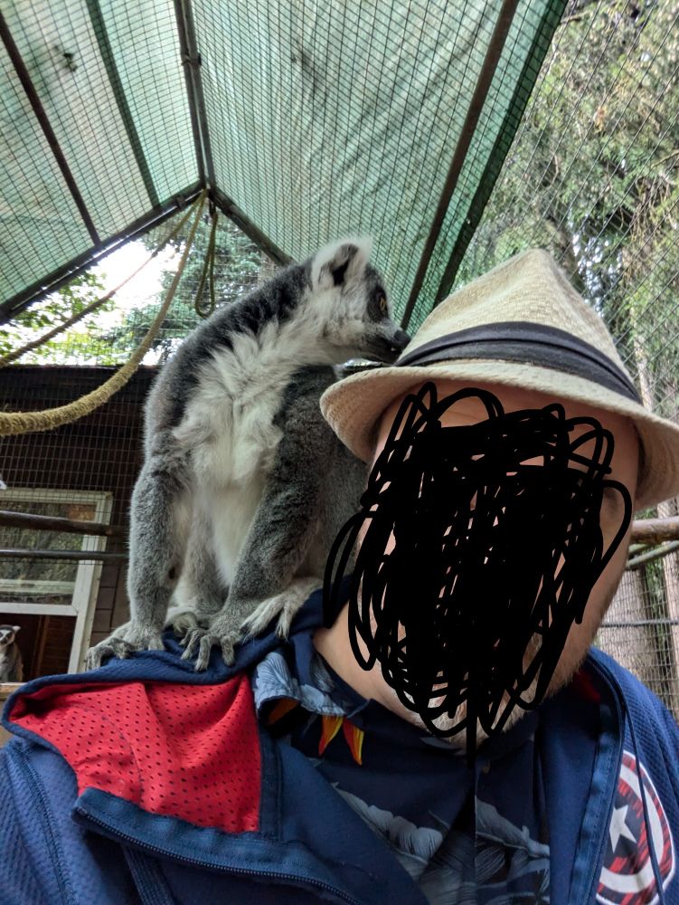 Image (face obscured) and a lemur named Lucky. He climbed up on my shoulder and refused to get down. 