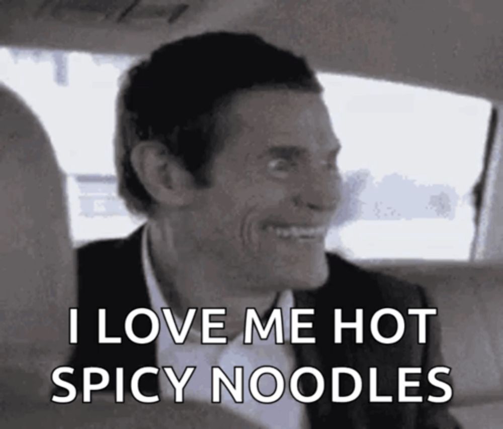 a man in a car is smiling and says i love me hot spicy noodles