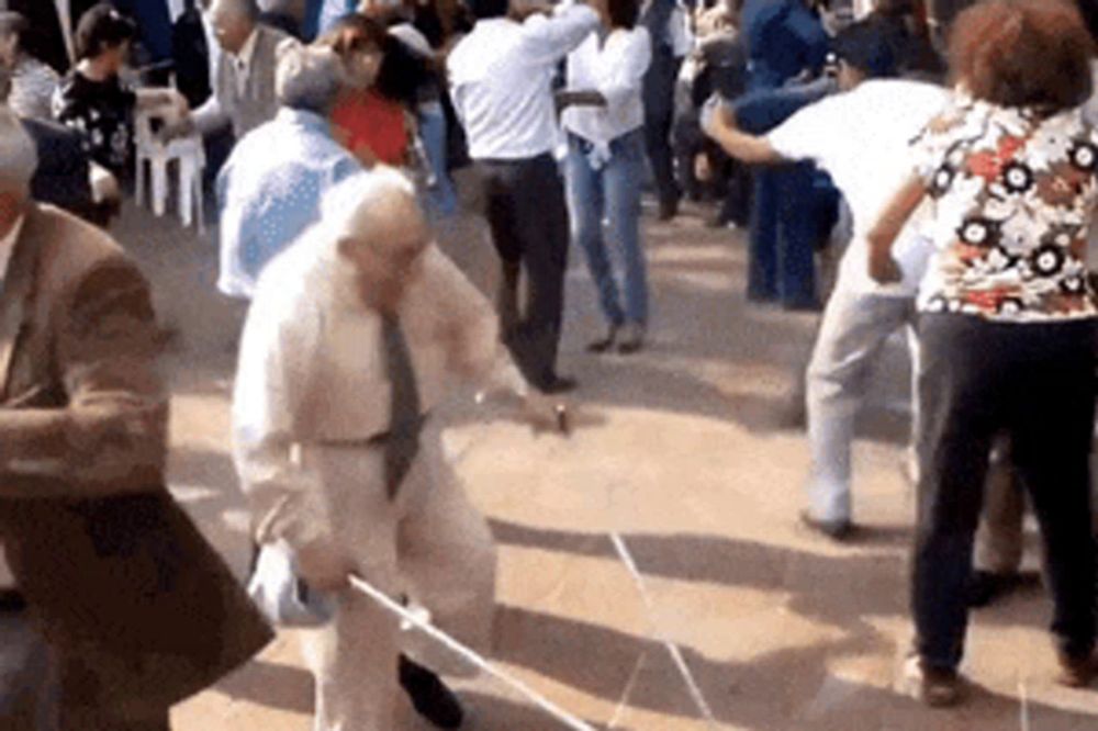 an elderly man with a cane is dancing in a crowd of people