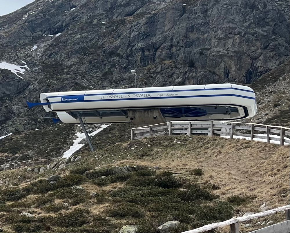 Mountain chair lift against rocky background 