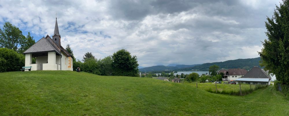 View of St Oswald’s church on a hillside with the Wörthersee in the background