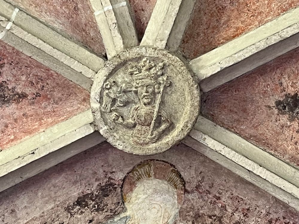 Keystone depicting Oswald holding a sceptre and wearing a crown with a raven 