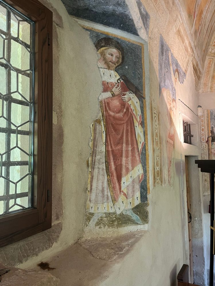 Close up of fresco from c.1370 depicting Oswald wearing royal robes, holding a sceptre and with a raven holding a ring perched on one of his hands