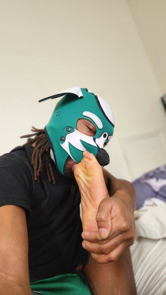 Zephyros sitting on his bed and displaying his sliver of flexibility by suckijg on his own toes.