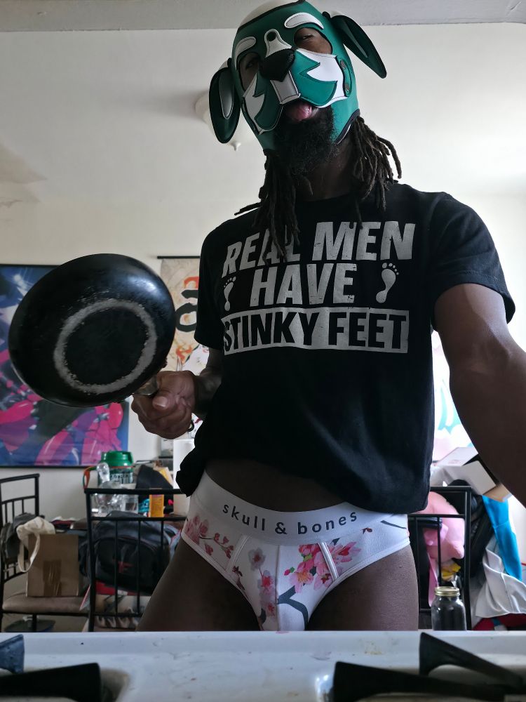 Zephyros w/frying in pain ready to make a meal while he lounges in his white floral briefs and one of his favorite t-shirts.