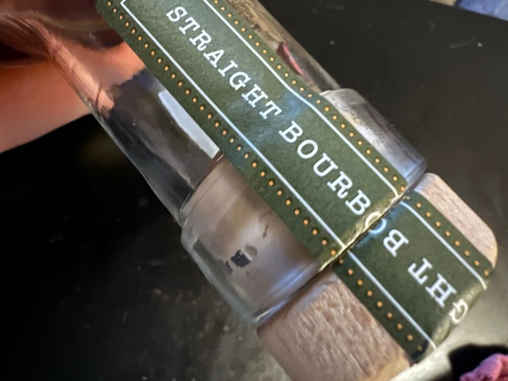 “Straight Bourbob” “thg” upside down labels on the neck of a bourbon bottle meet like a möbius strip bc it got turned around 180 degrees from how the sticker was printed. Kinda silly is all