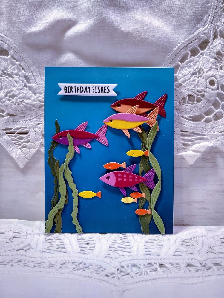 Handmade greeting card with fishes and seaweed on a blue ombre background and the phrase 