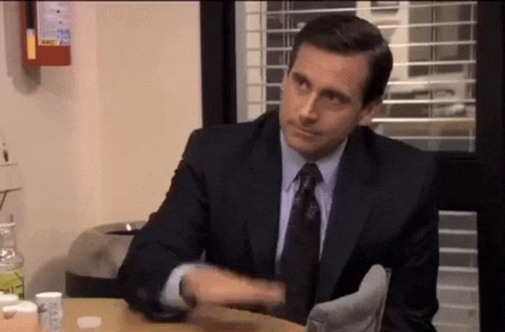 a man in a suit and tie is sitting at a table with bottles of pills .