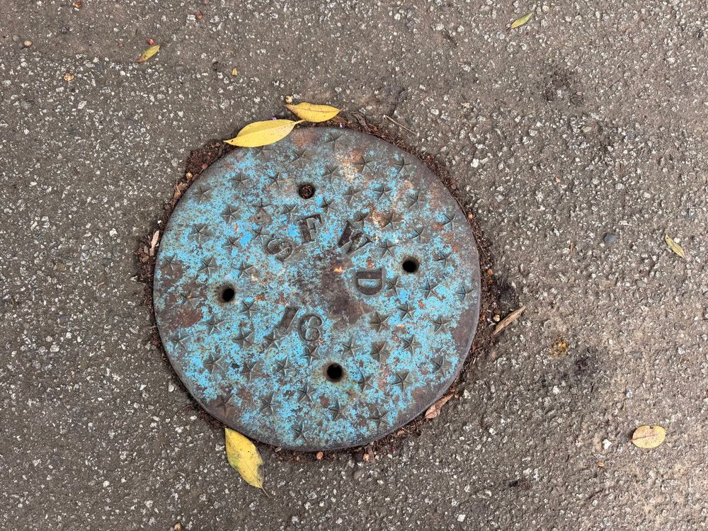 A maintenance cover with stars and the letters SFWD with light blue paint