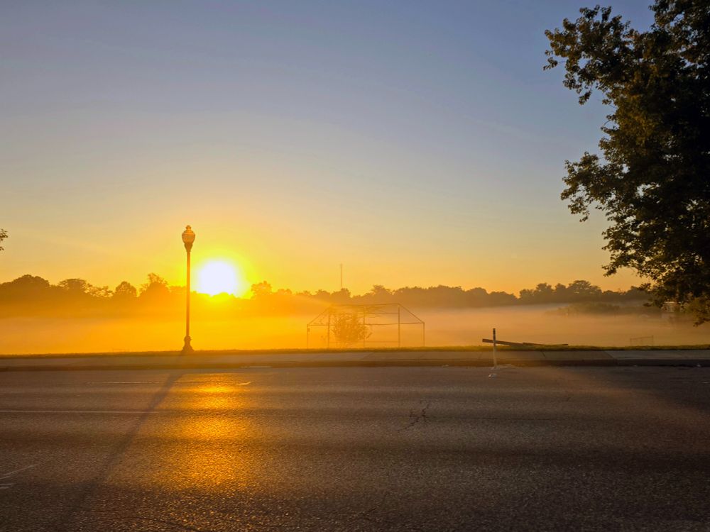 sunrise coming over the low-hanging fog covering Lake Clifton park in Baltimore. 