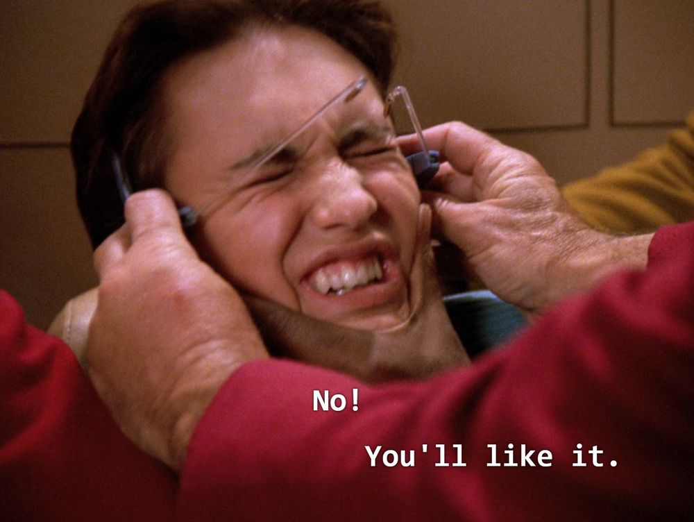 Wesley Crusher resists having gamergoggles violently put on his head.