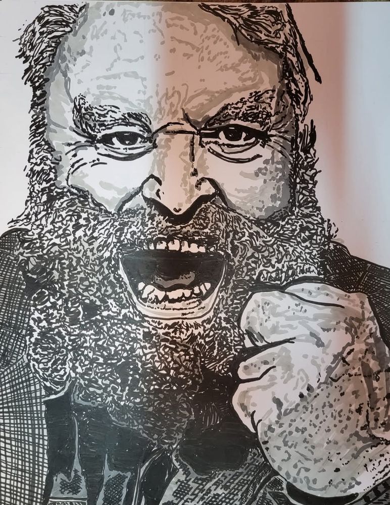 Brian Blessed with mouth and eyes open, holding up his left hand clenched in a fist