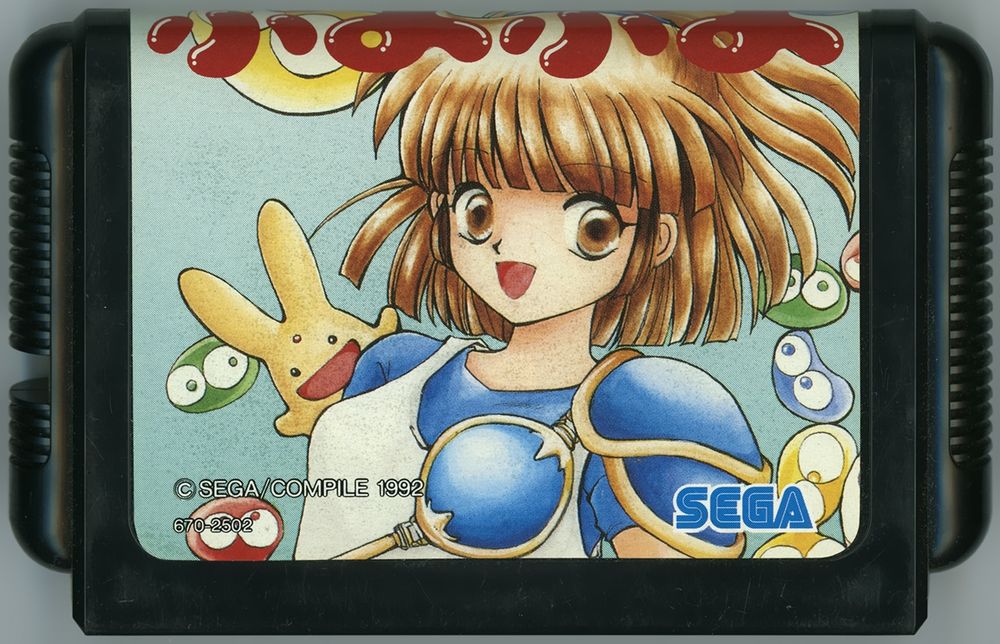 A Japanese "Puyo Puyo" cartridge for the "SEGA Mega Drive." Arle Nadja can be seen front and center, with Carbuncle appearing over her right shoulder. Puyos can also be seen to the left and right. Notice how the right side of the artwork with Arle's flowing hair and some Puyos matches up with what was underneath the South Korean Mean Bean cartridge art.