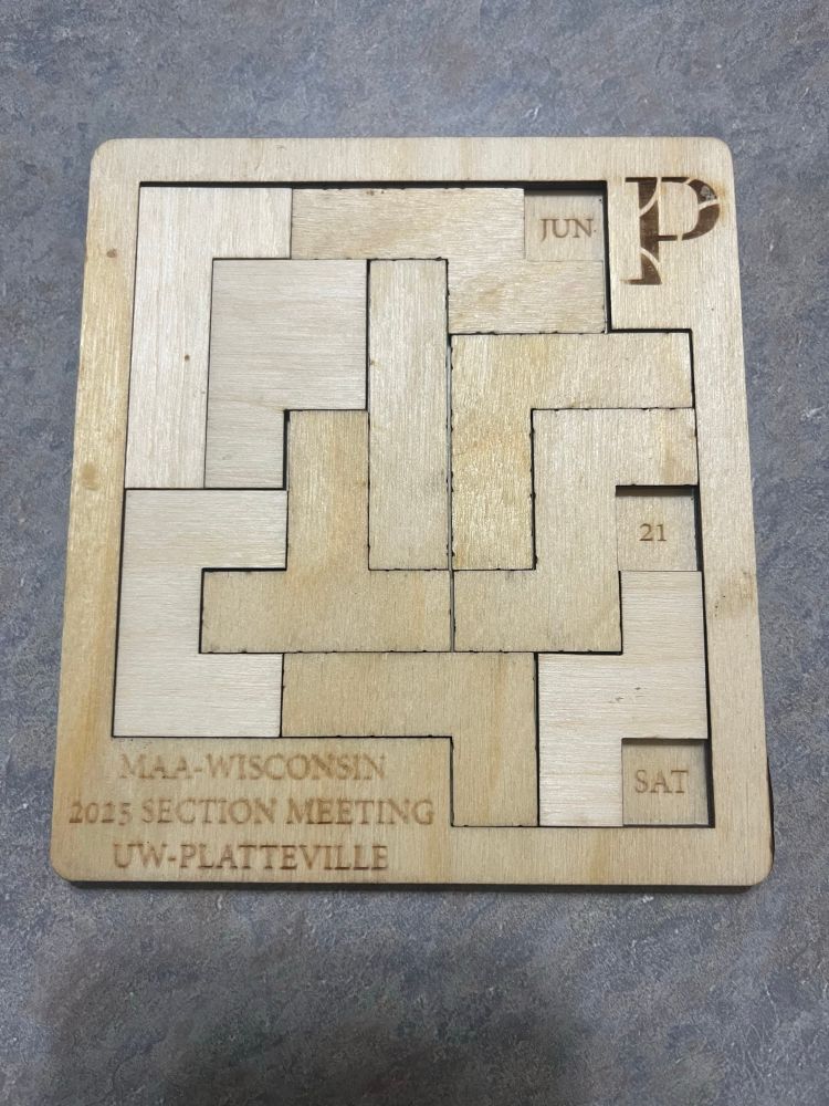Wooden puzzle with Tetris like pieces filled in to leave only Saturday, June 21 uncovered by pieces.