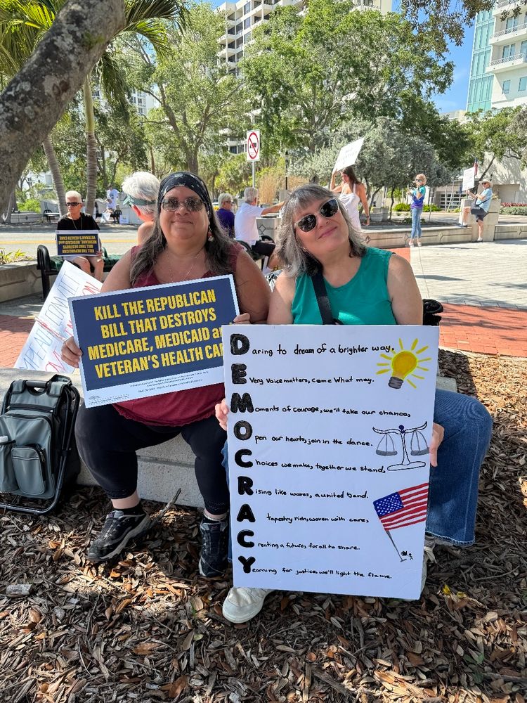 Two women holding protest signs in Florida